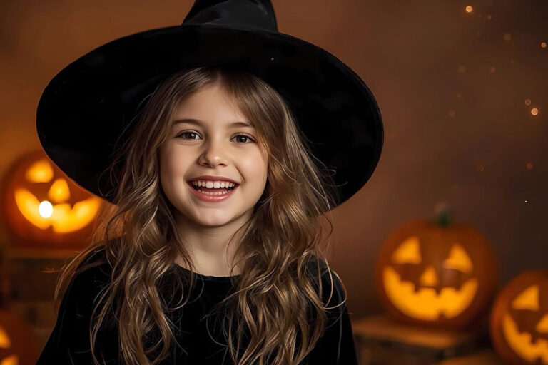 Adorable child dressed as witch enjoys Halloween evening surroun